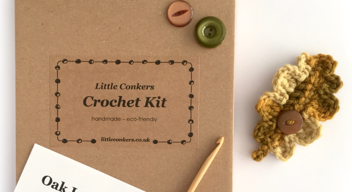 Kraft box containing woollen yarn, buttons crochet hook and pattern to make a crocheted oak leaf brooch.