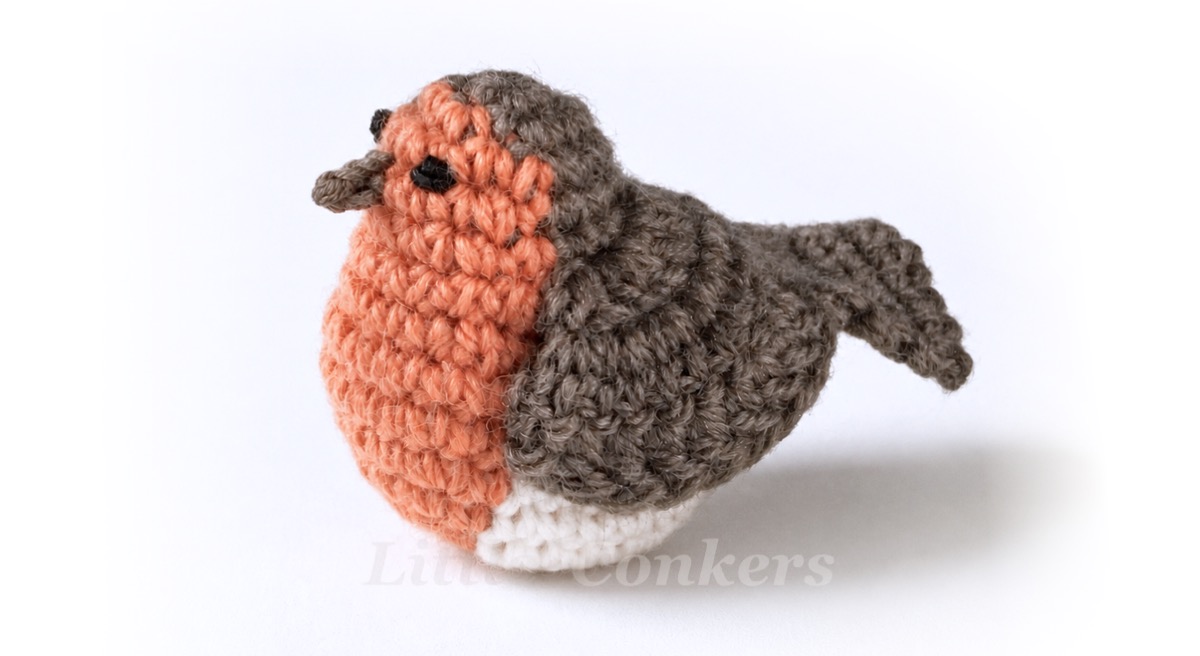 Realistic crocheted robin made in wool yarn.
