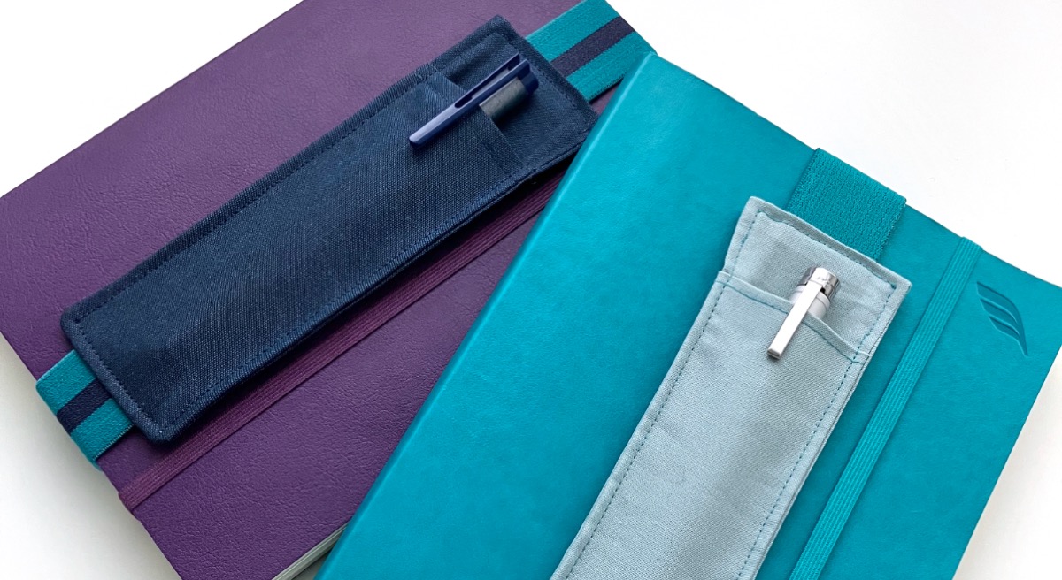Elasticated fabric notebook pen holders on notebooks.