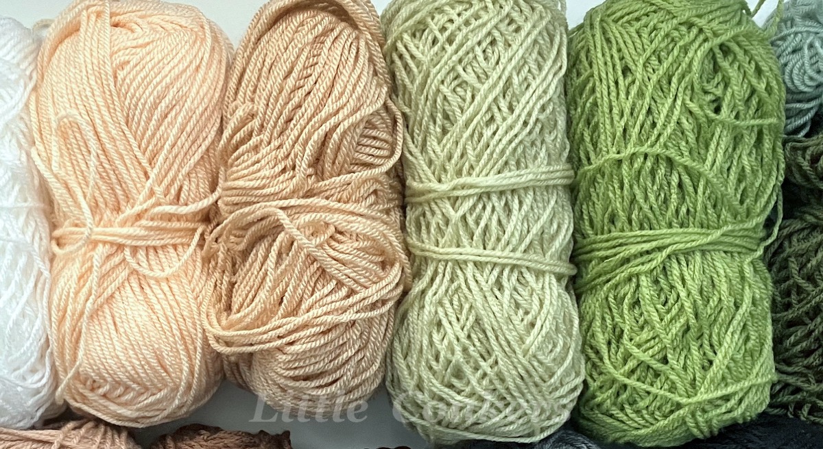 Several partial balls of yarn arranged in a colour gradient